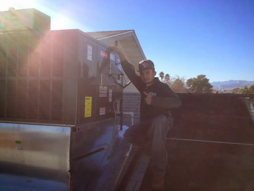 HVAC technician performing Air Duct Repair on a rooftop unit in Bayou Blue